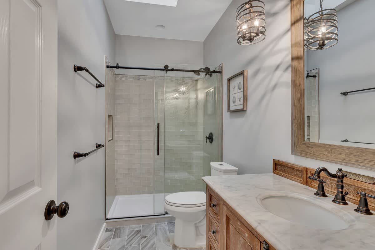 Step into your serene bathroom sanctuary with a luxurious walk-in shower, elegant marble countertops, and warm wood vanity perfect for your morning routine.