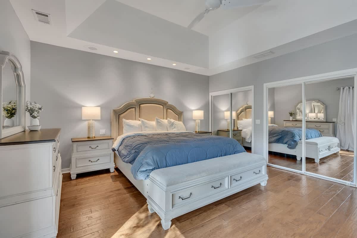 Sink into this serene bedroom where soft gray walls and elegant furnishings create your perfect retreat.