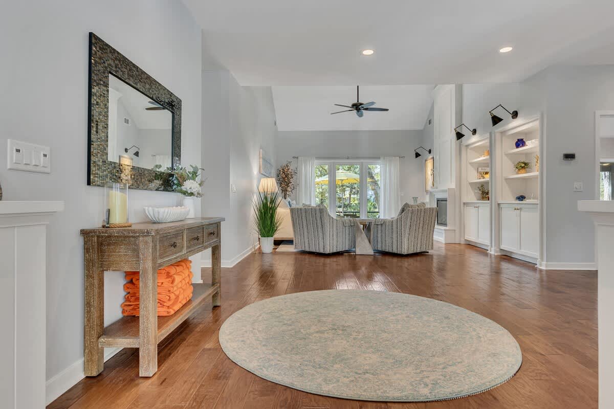 Relax in your elegant open-concept living space with gleaming hardwood floors, built-in shelving, and comfortable seating perfect for unwinding.