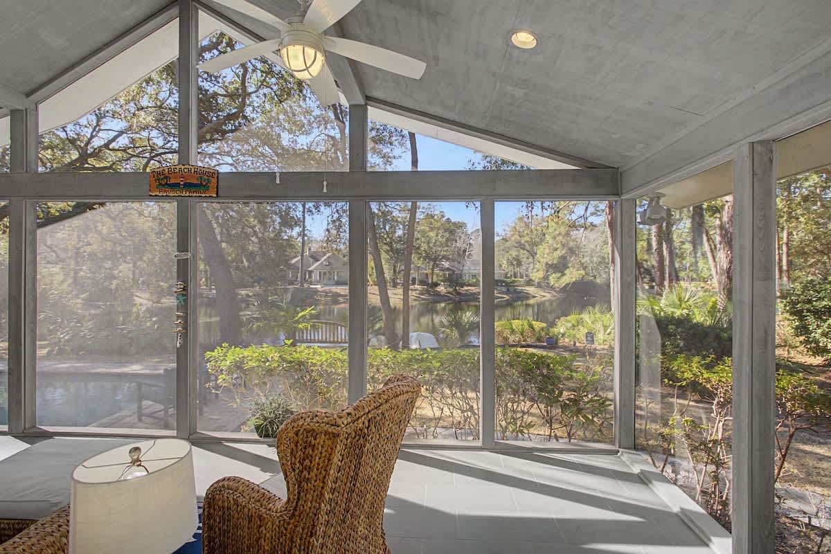 Your bright sunroom offers panoramic garden views through floor-to-ceiling windows, creating a peaceful retreat with natural light.