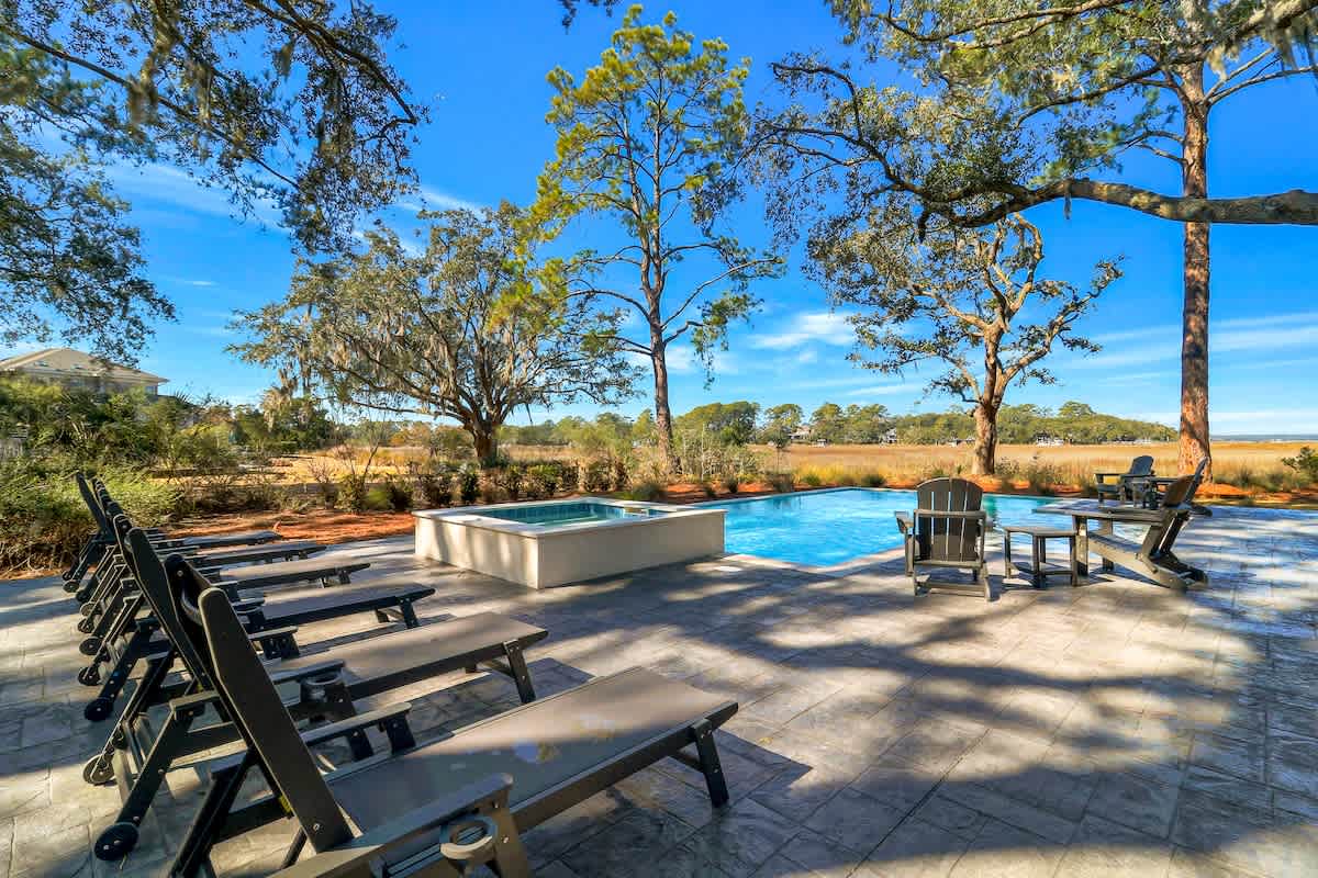 Dive into your private oasis surrounded by majestic trees and natural beauty, where sun-warmed loungers await your perfect poolside retreat.