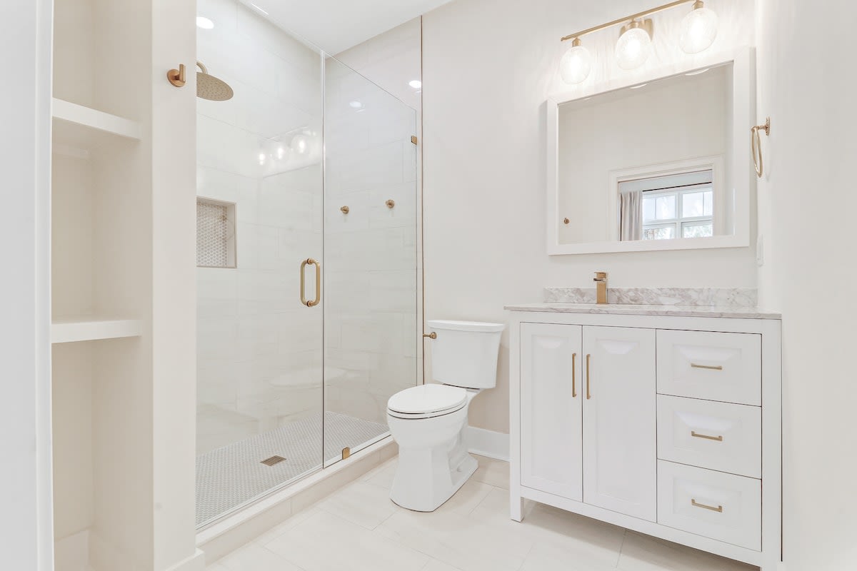 Your private spa-like bathroom features a luxurious walk-in shower with elegant gold accents and marble details throughout.