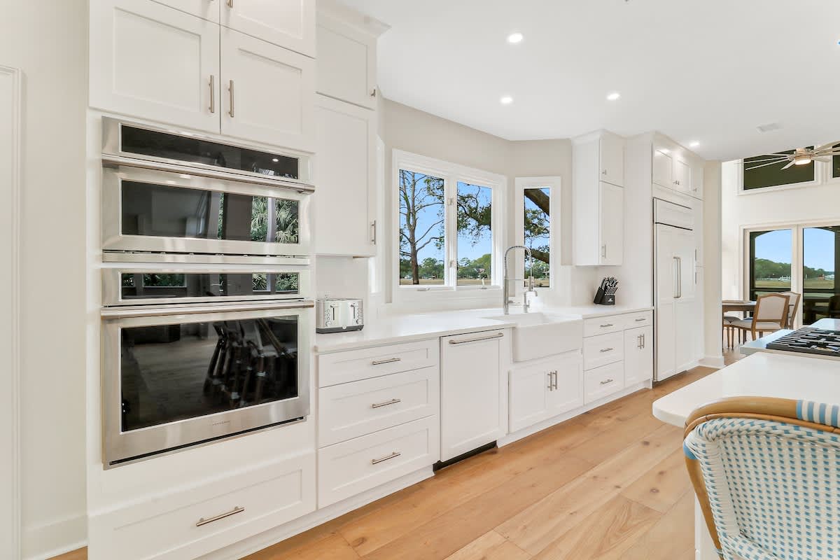 Cook with ease in your gourmet kitchen featuring premium appliances, abundant storage, and bright natural light streaming through garden windows.