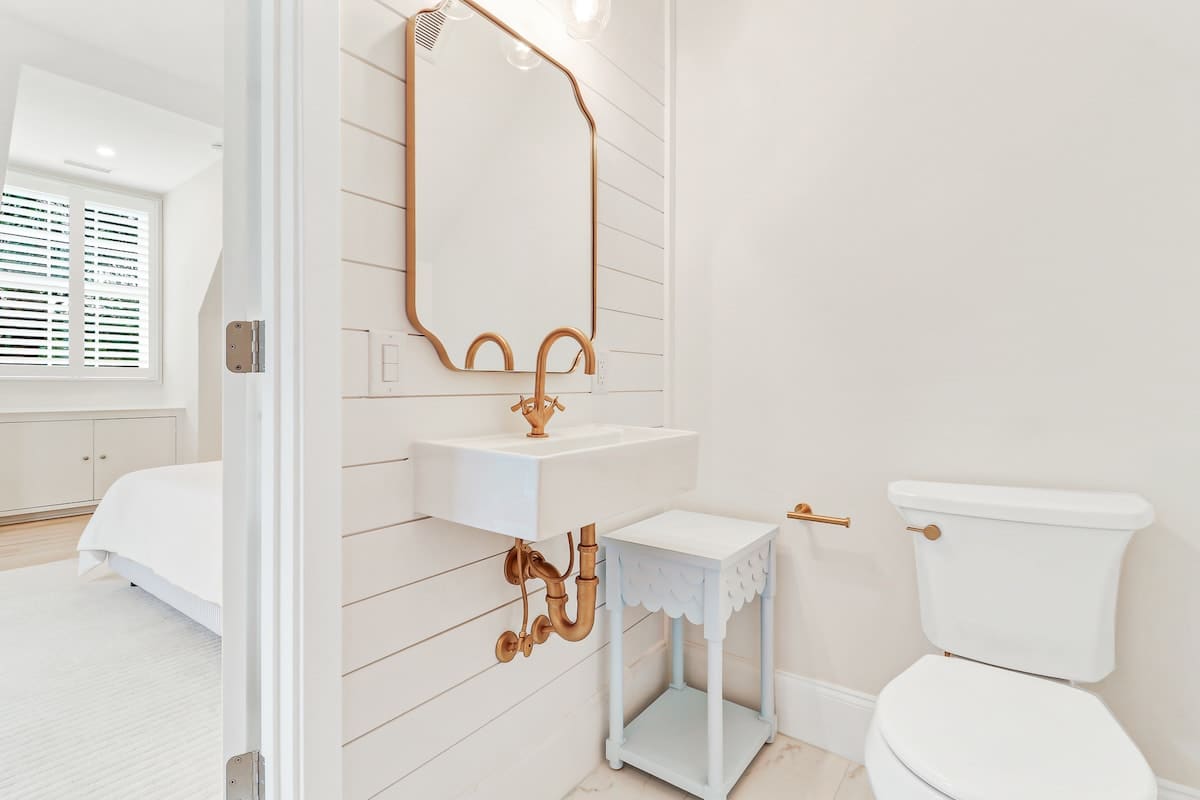 Step into your pristine white bathroom where copper accents add warmth and character to the clean, modern space.