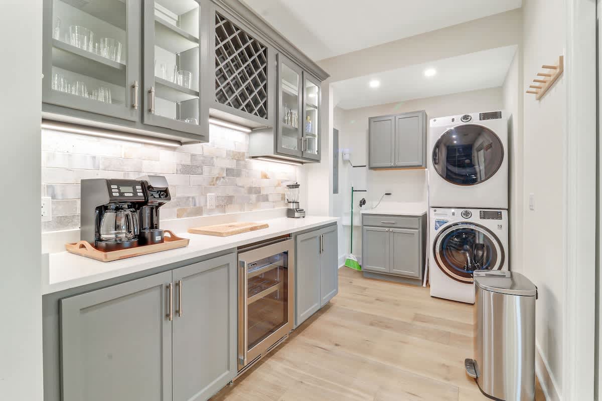 Your pantry and laundry combo makes daily routines effortless with premium appliances and elegant gray cabinetry.