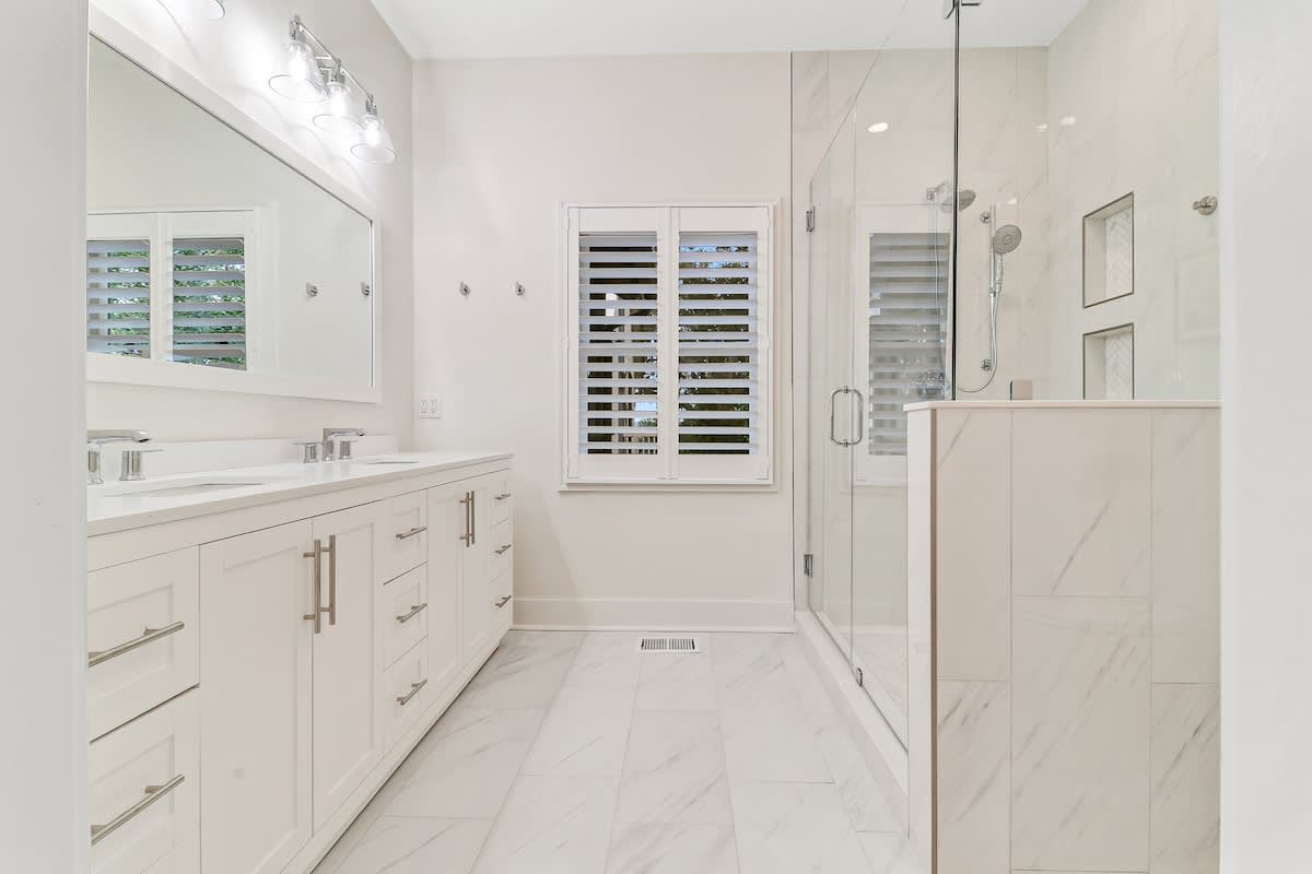 Step into your luxurious marble bathroom featuring a spacious glass shower and elegant vanity for your morning routine.