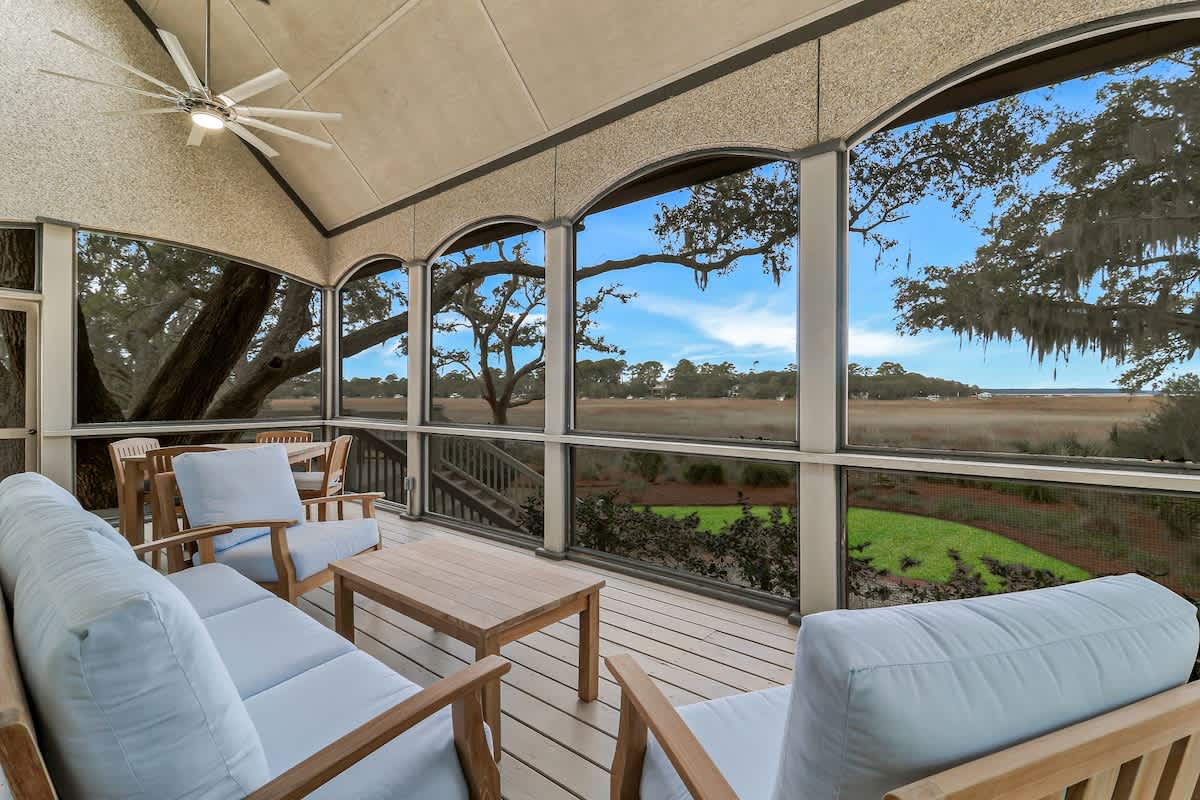 Relax in your screened porch with stunning marsh views, comfortable seating, and gentle ceiling fan breezes.