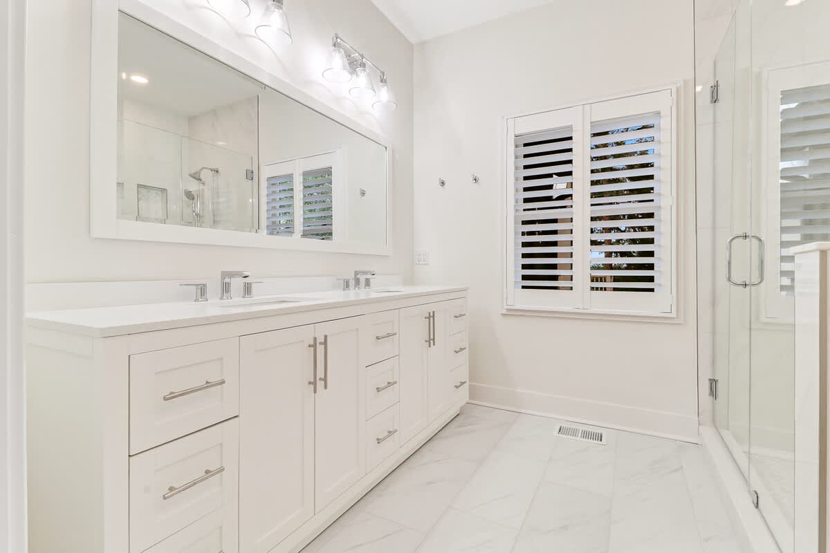 Step into your pristine marble bathroom oasis with dual vanities and sparkling fixtures that make your morning routine feel luxurious.