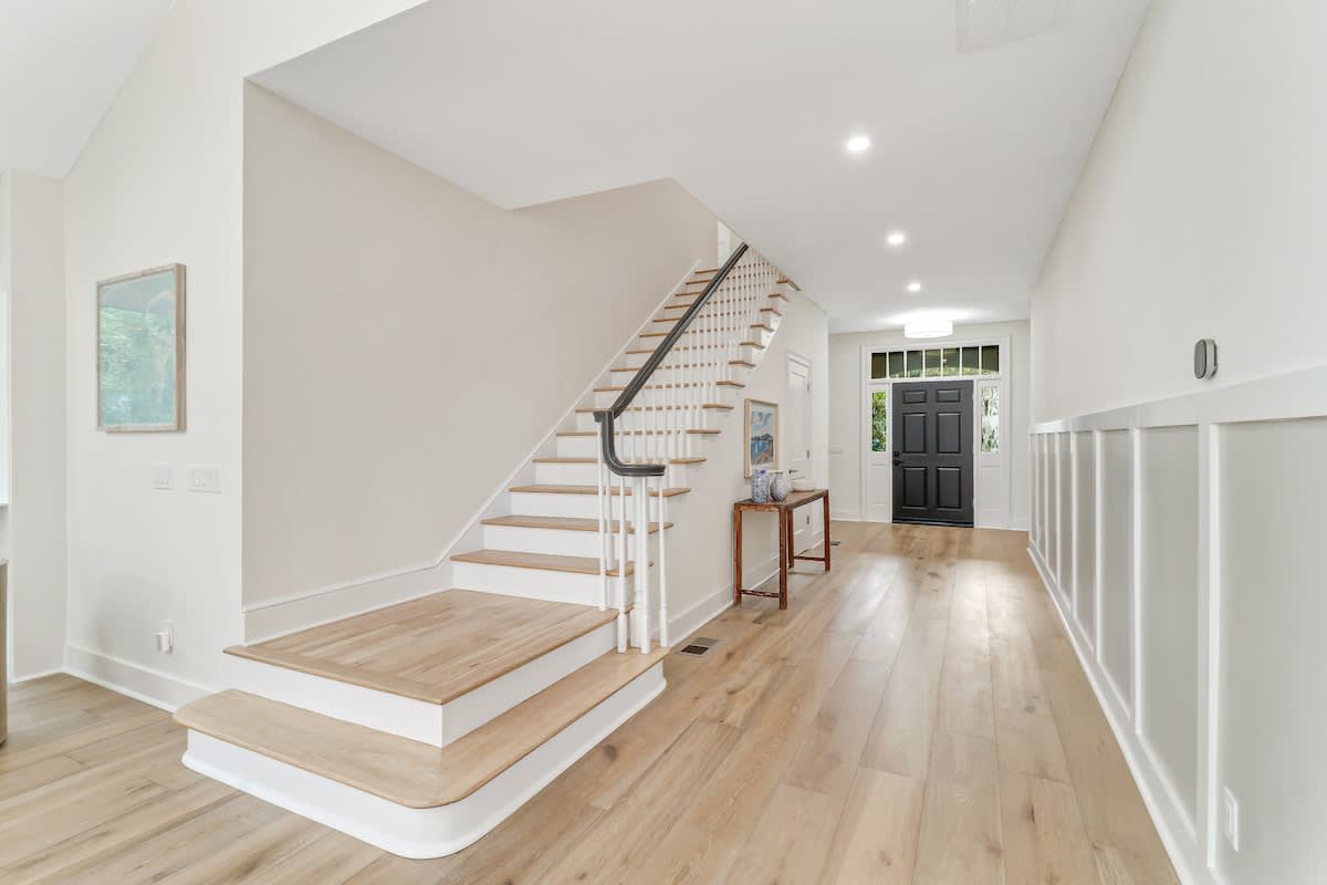 Step into your elegant foyer with warm hardwood floors and soaring ceilings that create an instantly welcoming atmosphere.