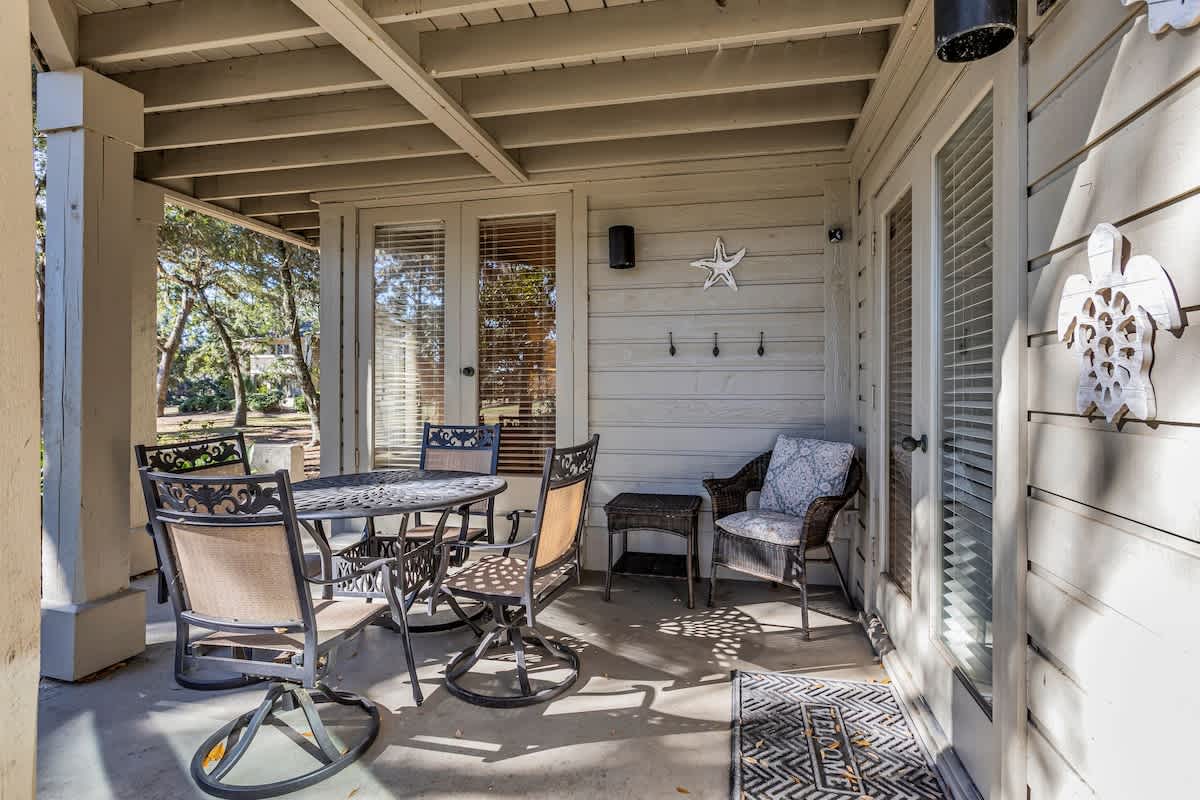 Your private covered patio invites peaceful mornings with coffee and evening conversations under the gentle shade of mature trees.
