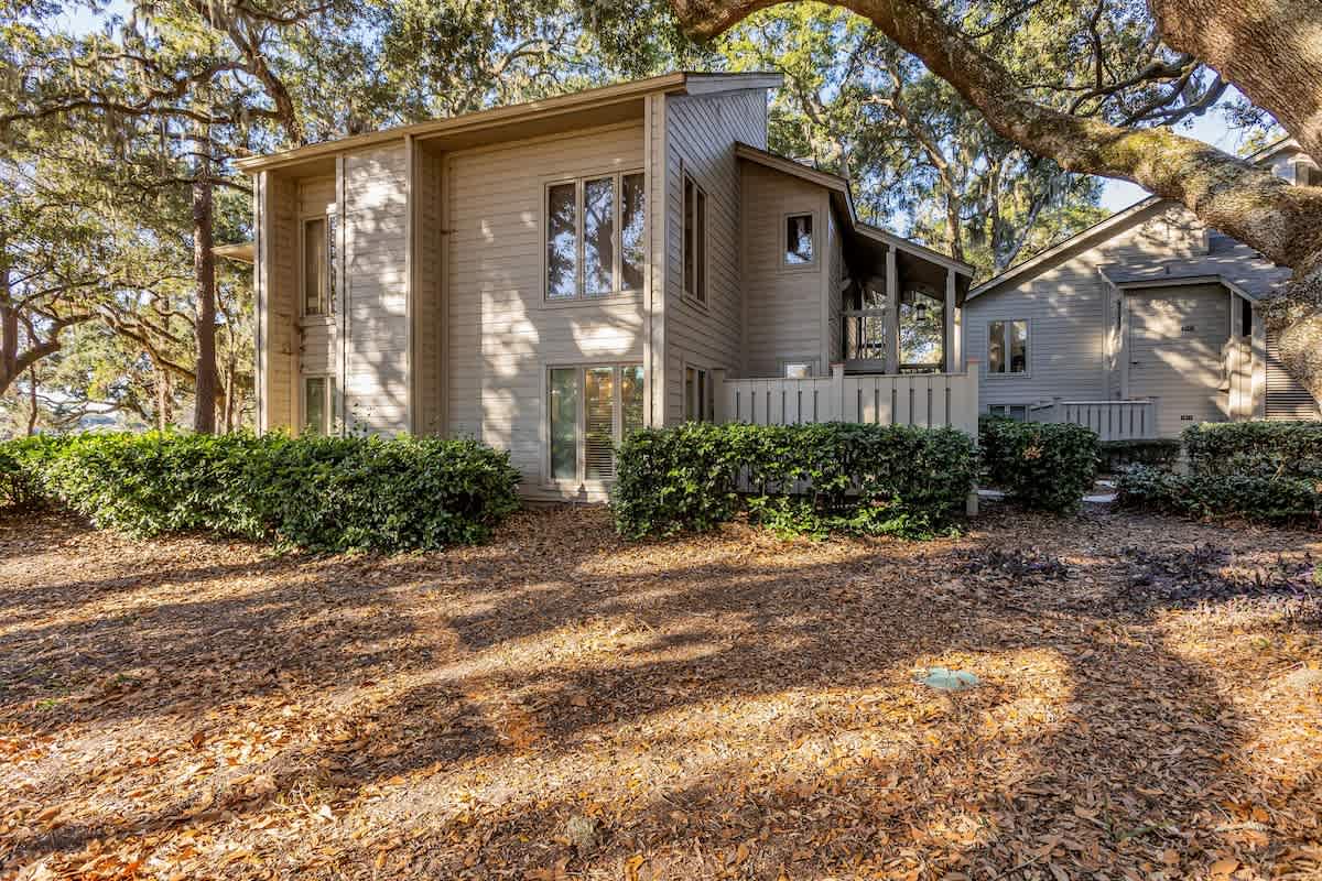 Charming multi-level home nestled among mature oak trees in a serene, landscaped setting.