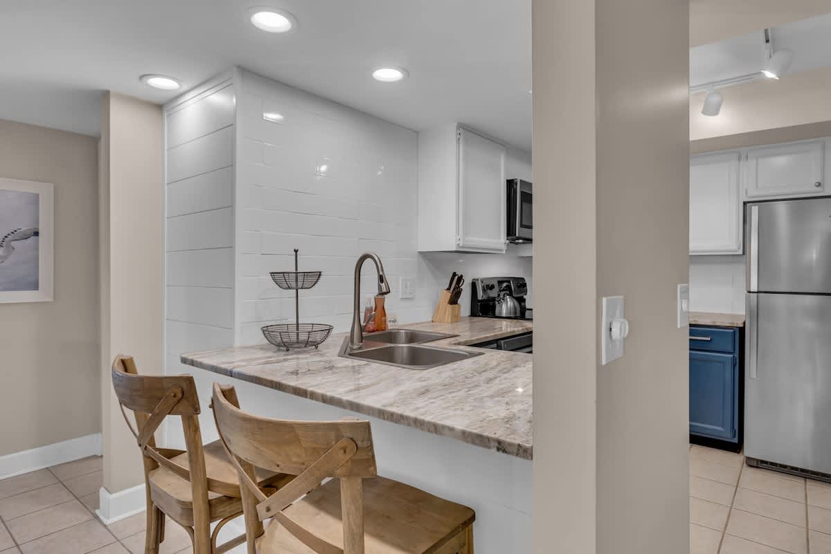 Your sleek kitchen features marble countertops and modern appliances, perfect for preparing meals and casual dining at the breakfast bar.