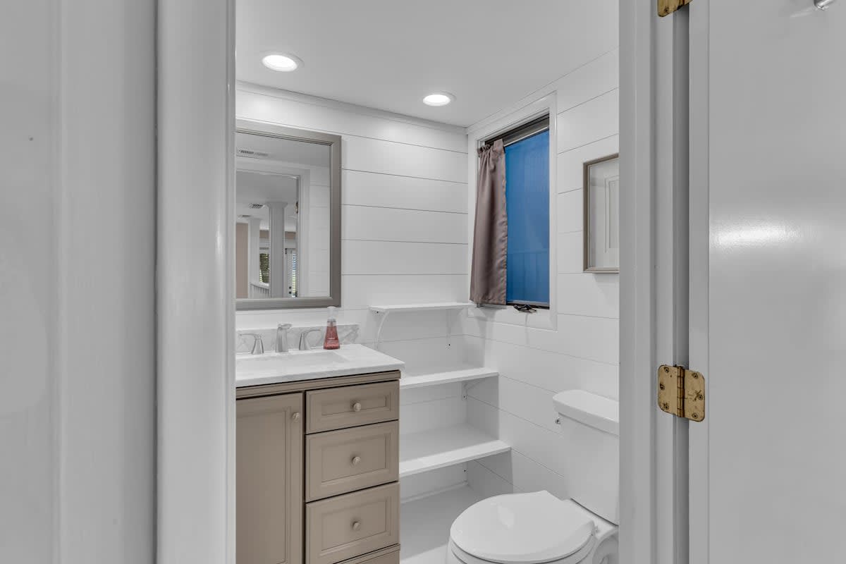 Refresh in your beautifully appointed bathroom with elegant fixtures, a soaking tub, and crisp white shiplap walls.