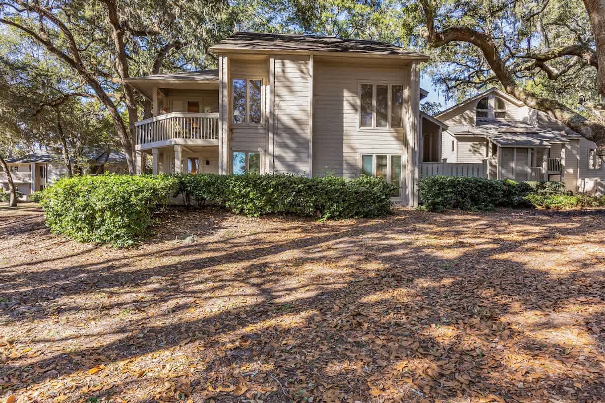 A charming two-story retreat nestled among mature oak trees, offering peaceful surroundings and natural privacy in a serene wooded setting.