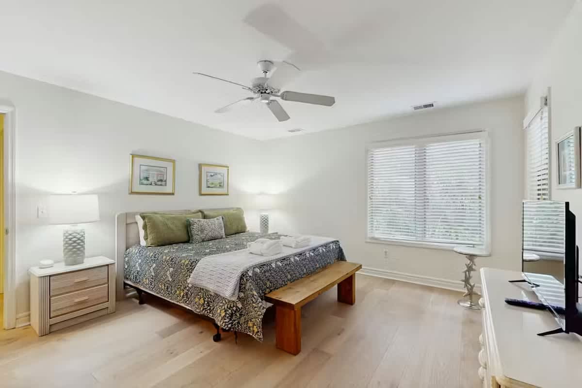 Relax in your serene bedroom sanctuary with natural light, ceiling fan breeze, and peaceful decor creating the perfect retreat.