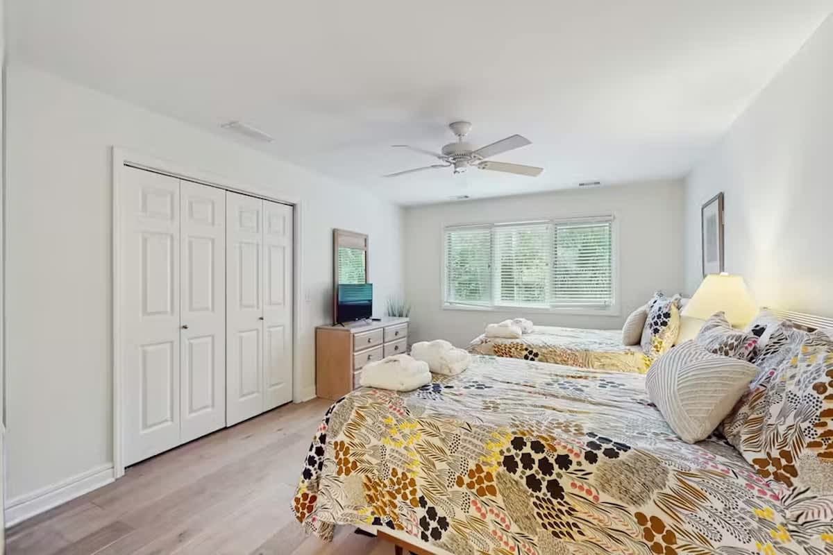 Wake up refreshed in your bright, airy bedroom with twin beds draped in cheerful patterns and gentle natural light.