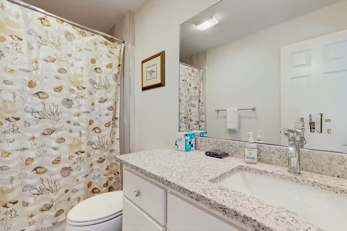Refresh in your coastal-themed bathroom with charming seashell wallpaper and granite counters, complete with premium amenities for your comfort.
