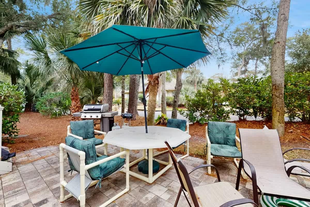 Gather around your private patio table under swaying palms, where teal cushions invite lazy afternoons and the grill awaits your culinary adventures.