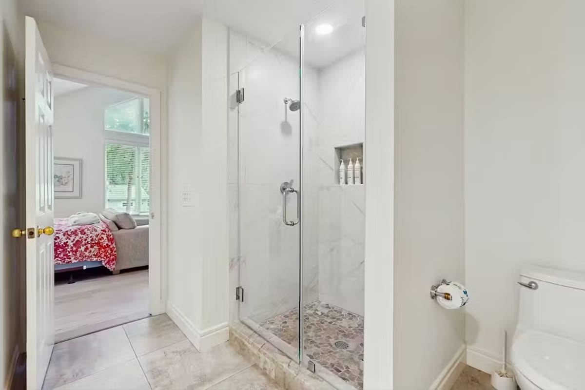 Step into your private spa-like retreat with marble walls and spacious glass shower after exploring the day.