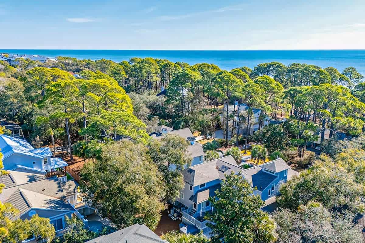Aerial view of the coastal property nestled among lush trees, just moments from pristine beaches and turquoise waters.