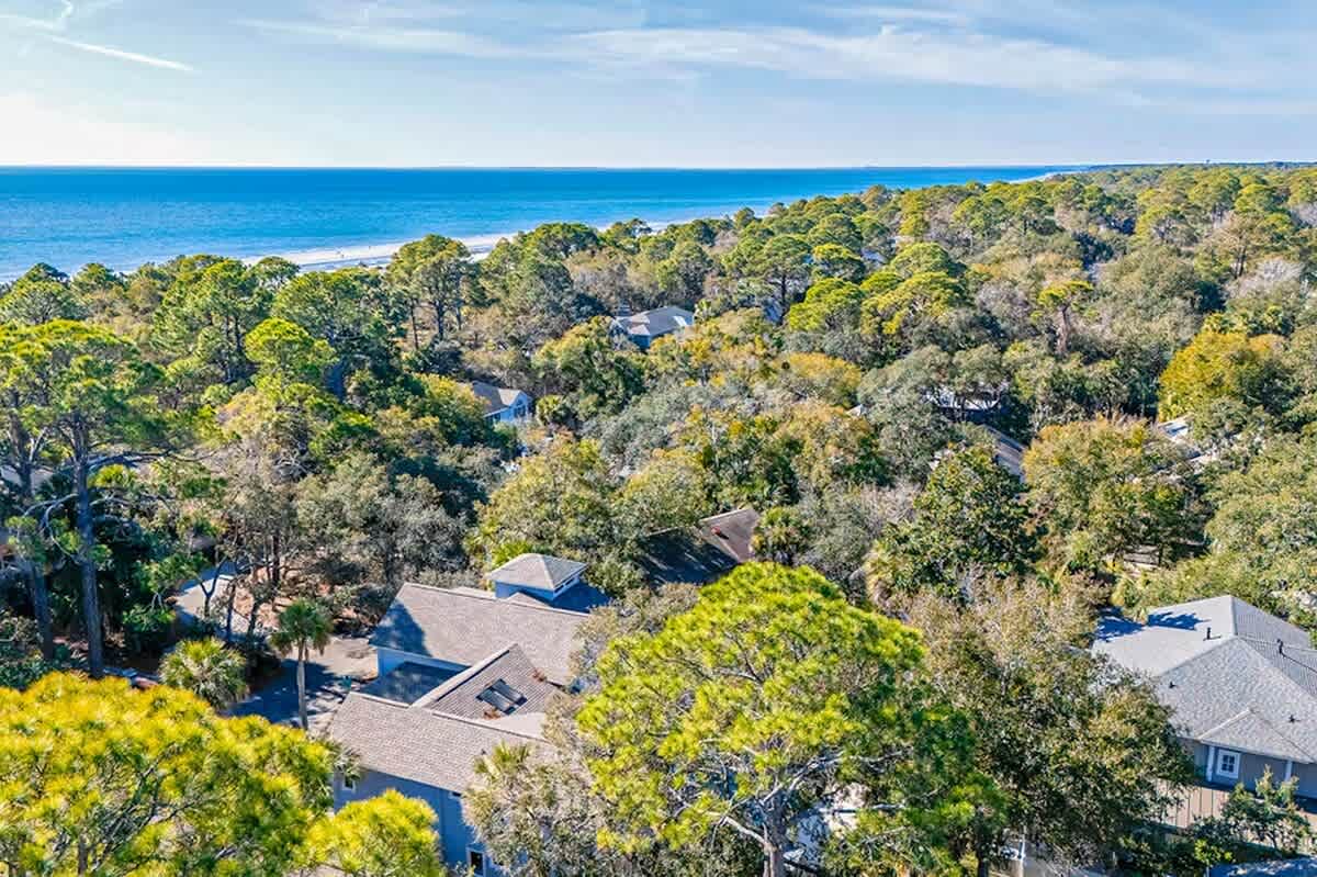 Coastal retreat nestled among mature trees, just steps from pristine beach access.