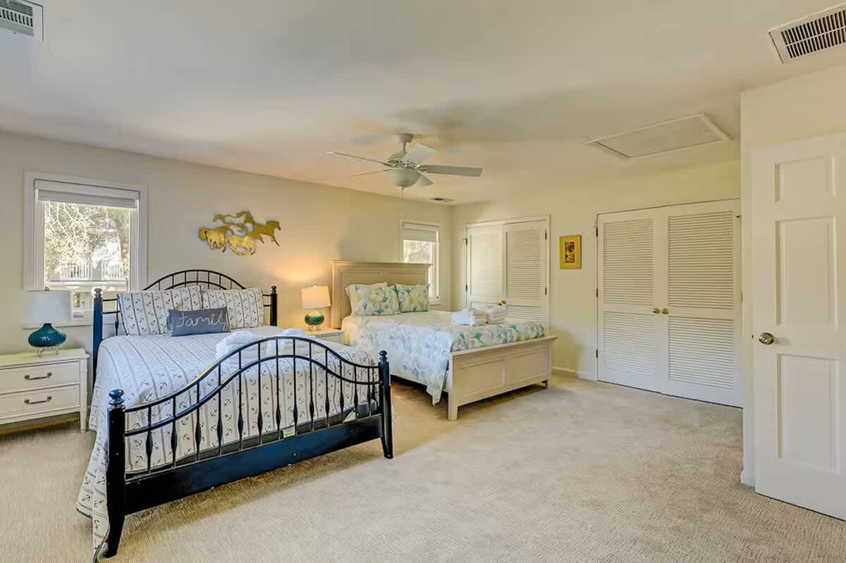 Spacious bedroom with comfortable beds for your family, featuring plenty of natural light and ample storage for all your vacation essentials.