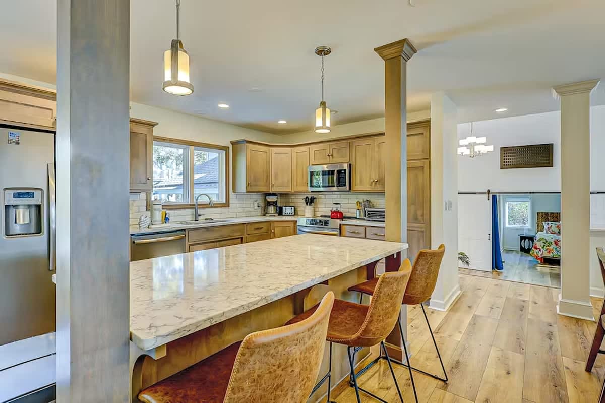 Gather around this stunning kitchen island where granite countertops and warm wood cabinetry create your perfect cooking and conversation space.