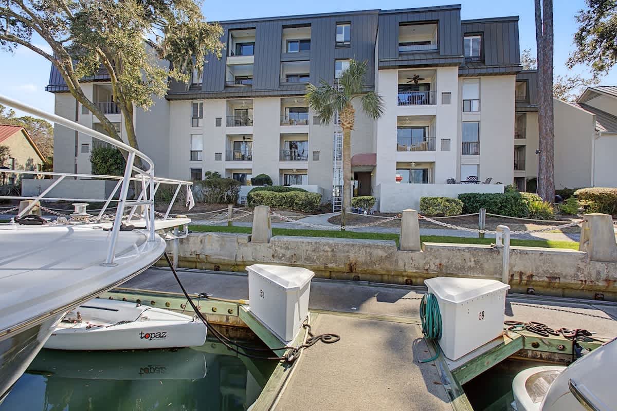 Modern waterfront property with private boat dock and tropical landscaping in a peaceful marina setting.