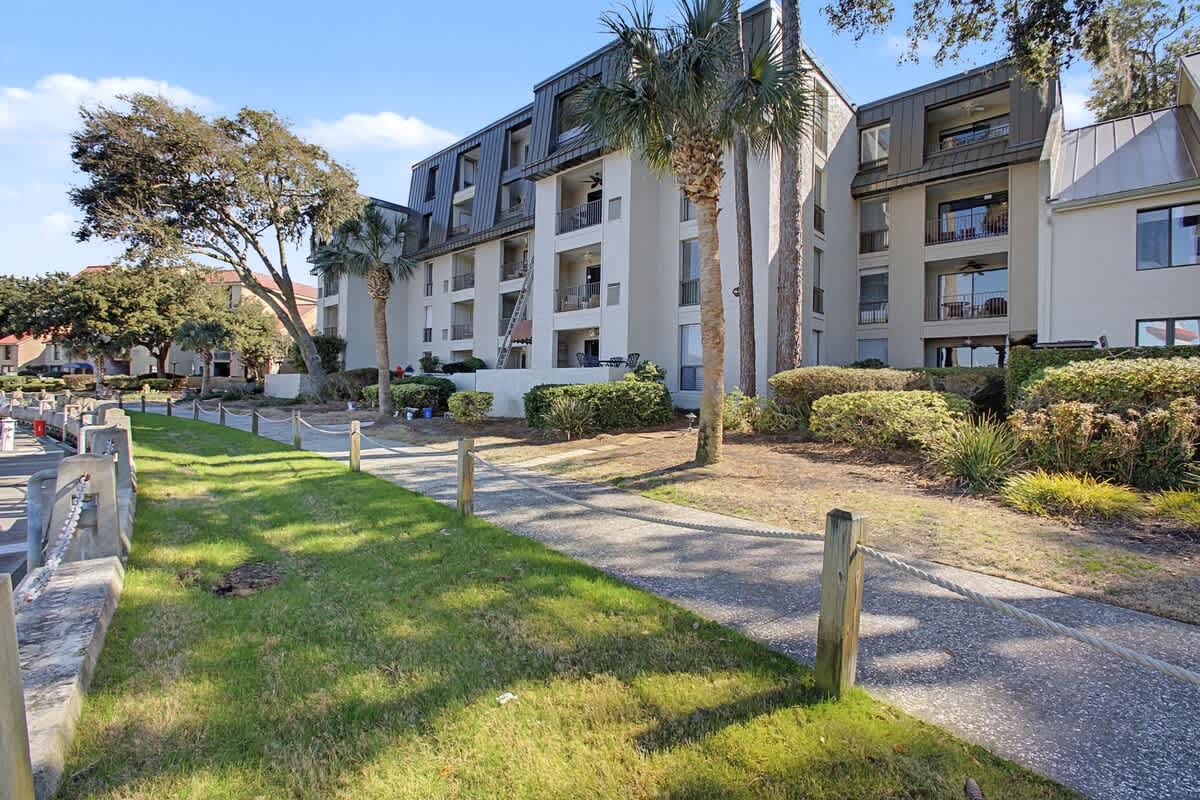 A modern apartment complex set among palm trees and manicured gardens, offering a peaceful residential retreat.