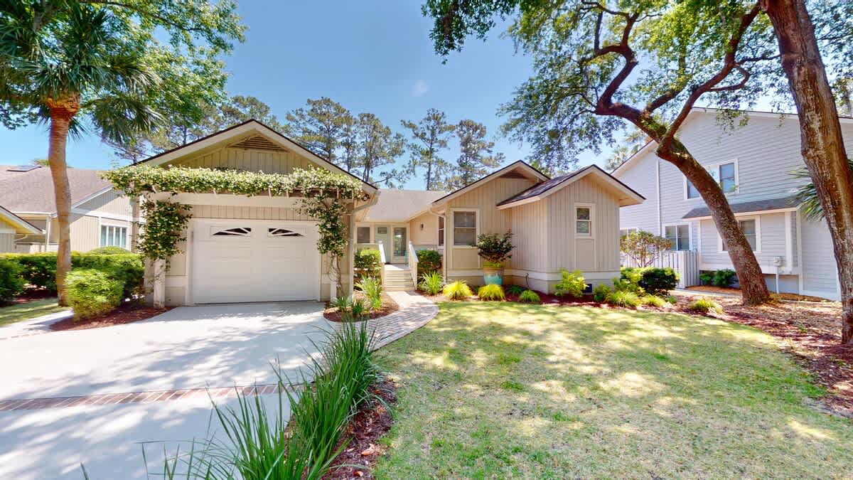 Charming coastal retreat with mature trees and landscaped grounds in a peaceful residential neighborhood.