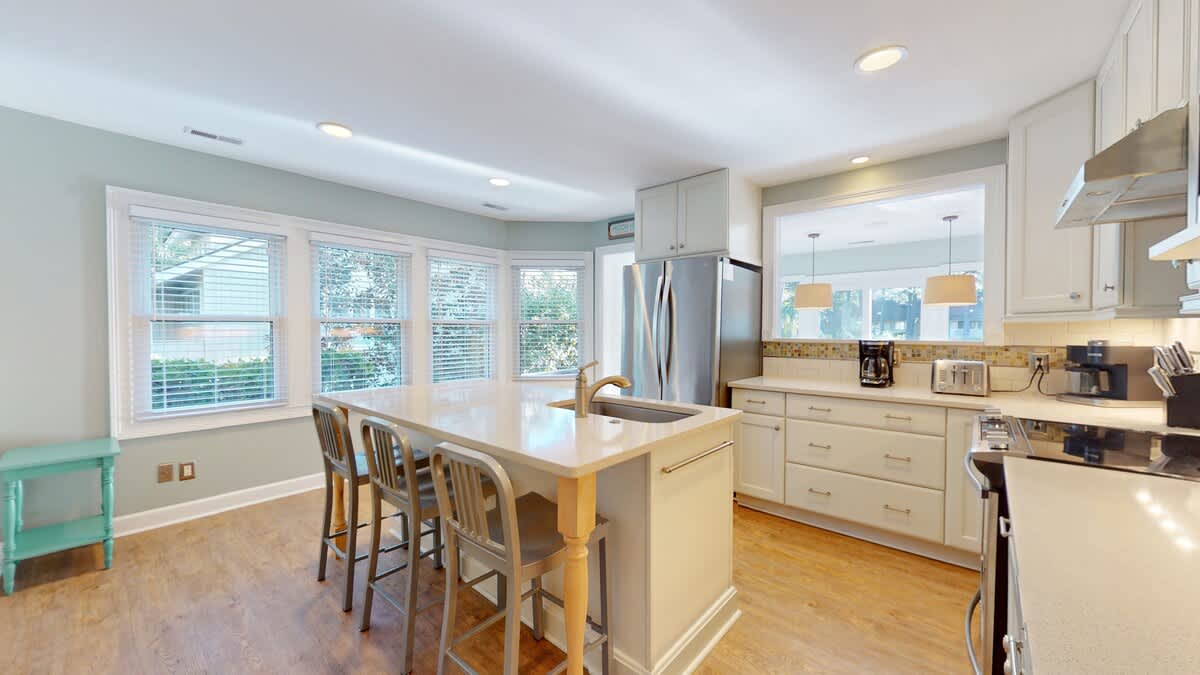 Spacious kitchen with white cabinets, granite countertops, and breakfast island creates your perfect culinary retreat.