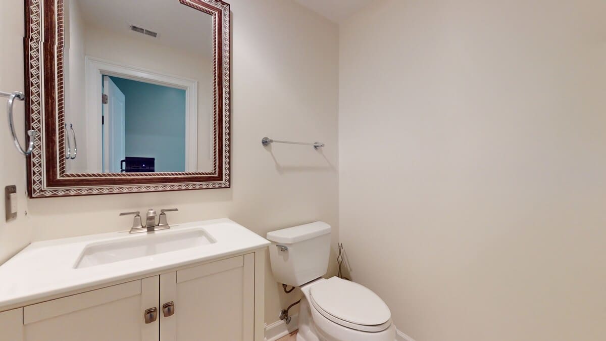 Your private powder room features elegant details with a beautiful decorative mirror and pristine fixtures for your convenience.
