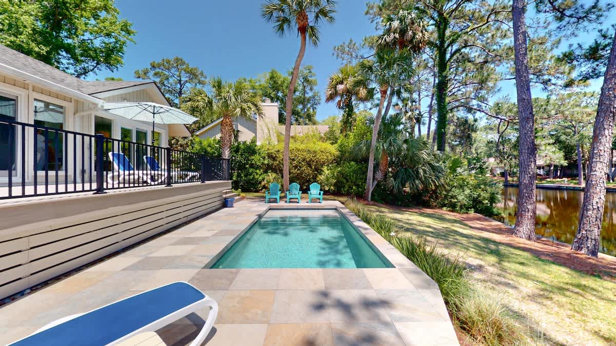 Dive into your private oasis surrounded by towering palms and lush tropical landscaping, perfect for poolside relaxation.