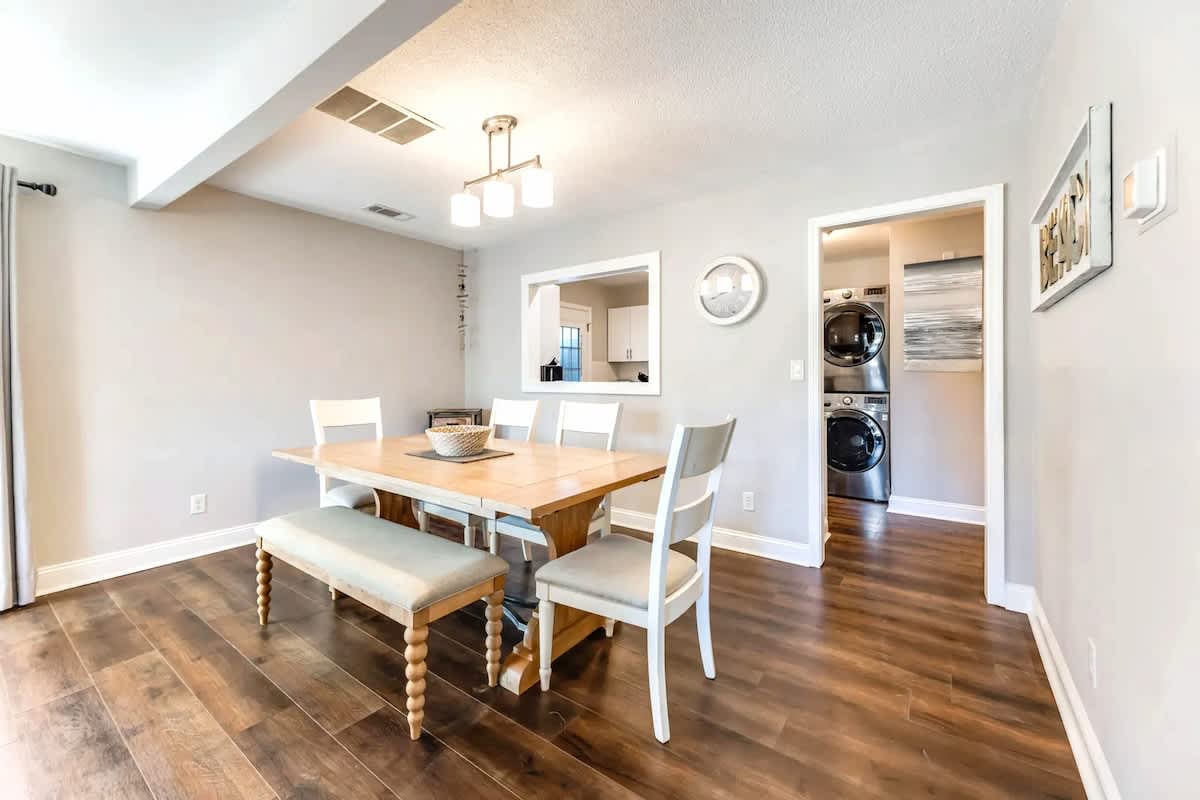 Gather around the warm wood dining table where memories are made, with convenient laundry facilities just steps away.