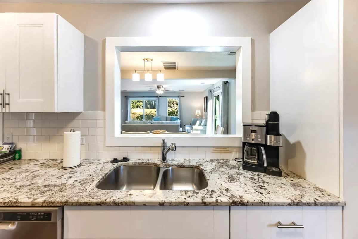 Your granite countertops and coffee maker await, while the pass-through window connects you to the bright living space beyond.