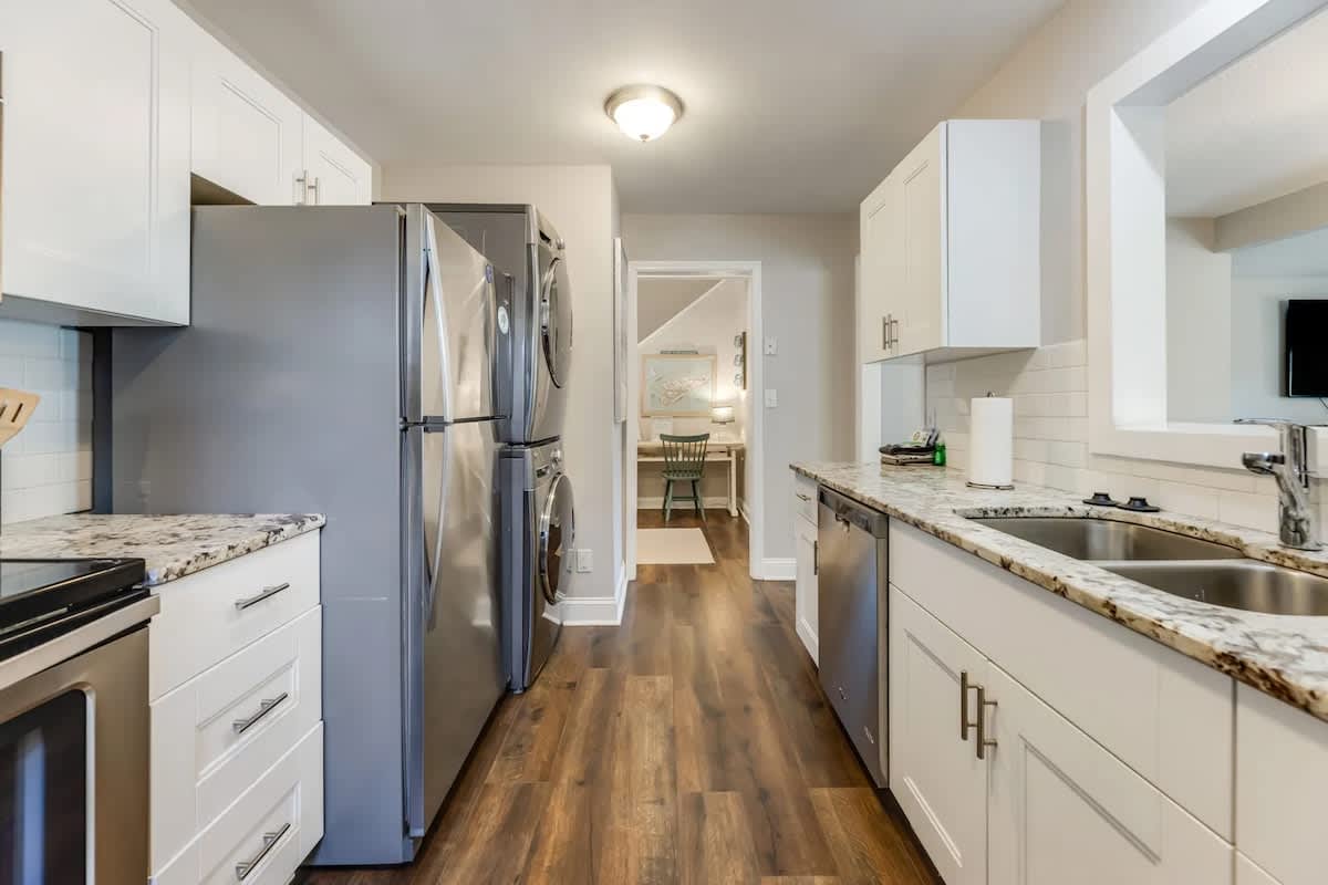 Cook your favorite meals in this bright, fully-equipped galley kitchen featuring granite countertops, stainless steel appliances, and ample cabinet storage.