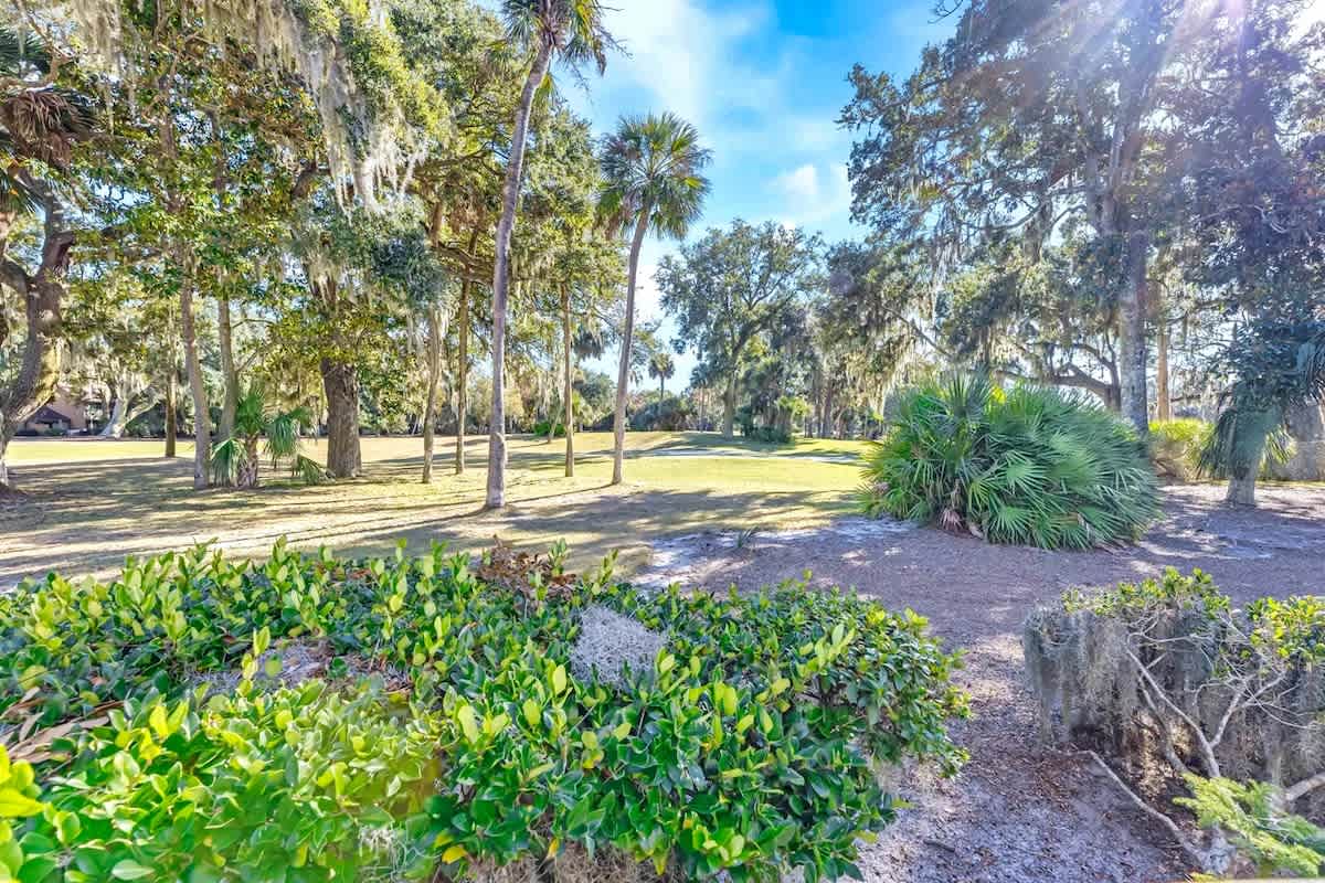 Peaceful landscaped grounds feature mature oak trees draped with Spanish moss and tropical palms creating natural shade throughout the property.