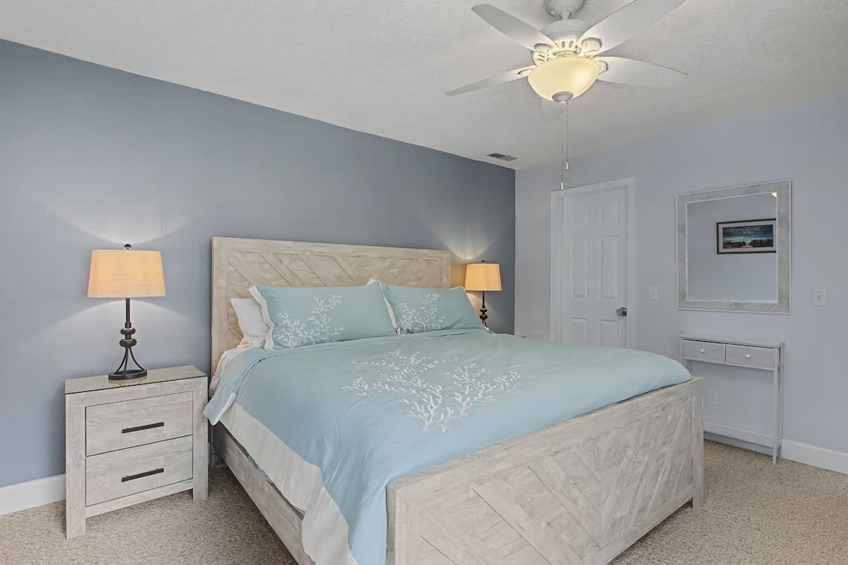 Rest peacefully in this calming bedroom with soft coastal colors, comfy queen bed, and gentle ceiling fan keeping you cool.