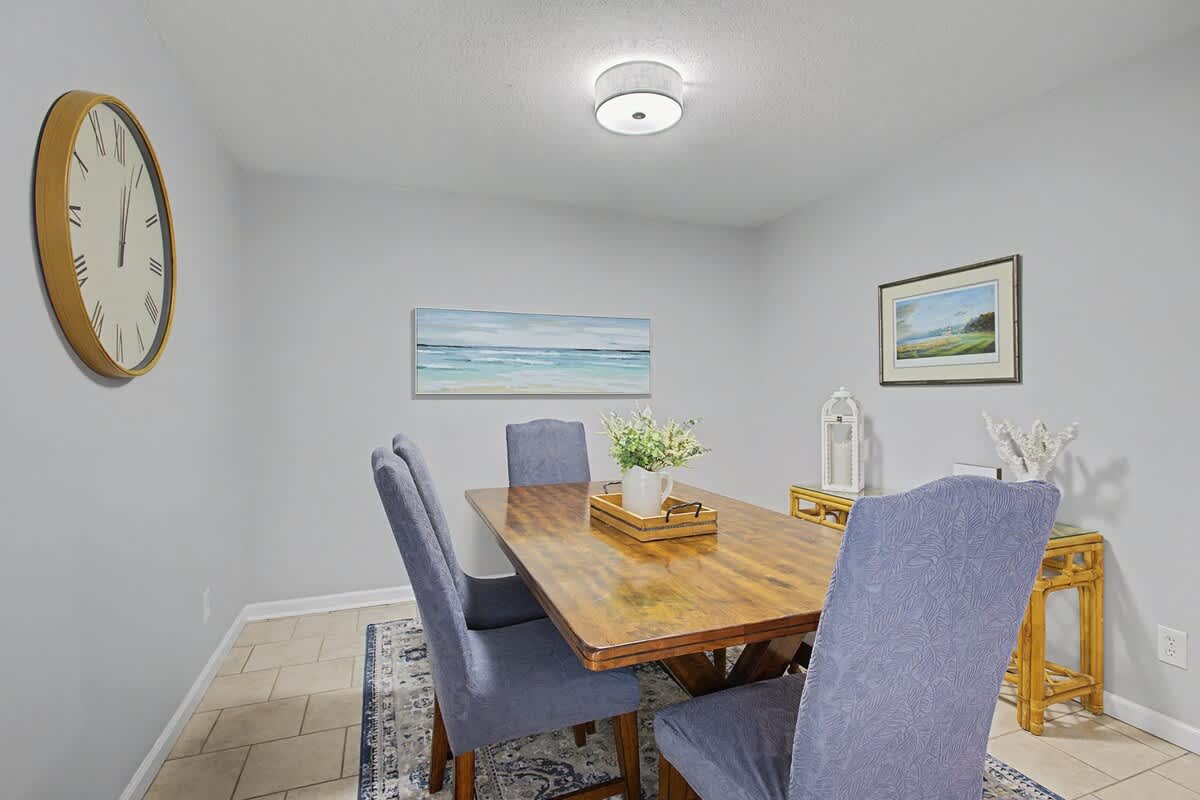Gather around this elegant dining table for memorable meals together, with coastal artwork creating a serene backdrop for your conversations.