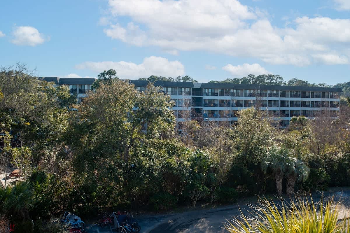 Modern apartment complex nestled among lush greenery offers a peaceful retreat with natural surroundings and contemporary architecture.