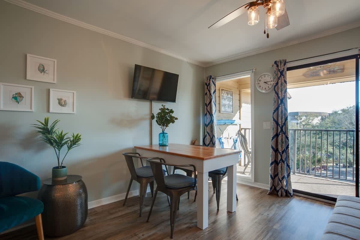Your bright dining space features modern seating and opens to a private balcony with views of the surrounding area.