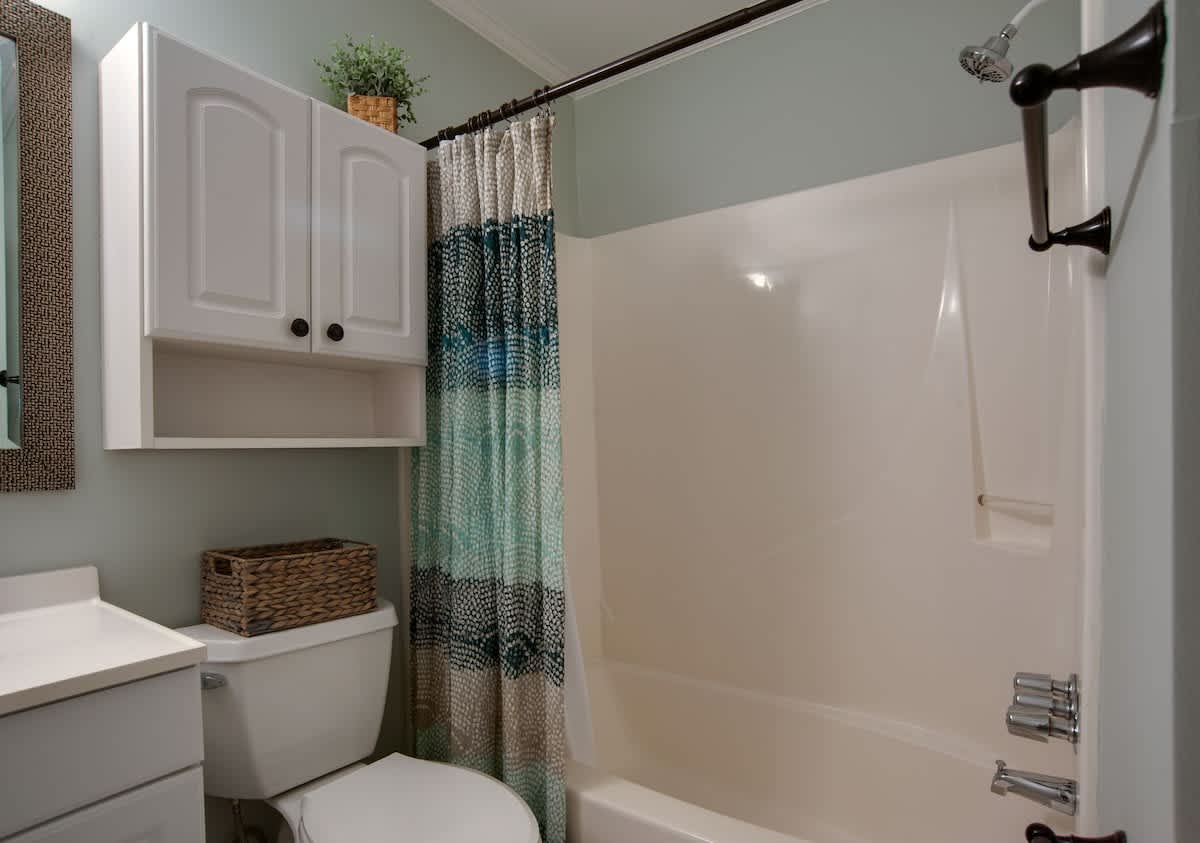 Your private bathroom offers a refreshing shower-tub combo with thoughtful storage and charming coastal touches.