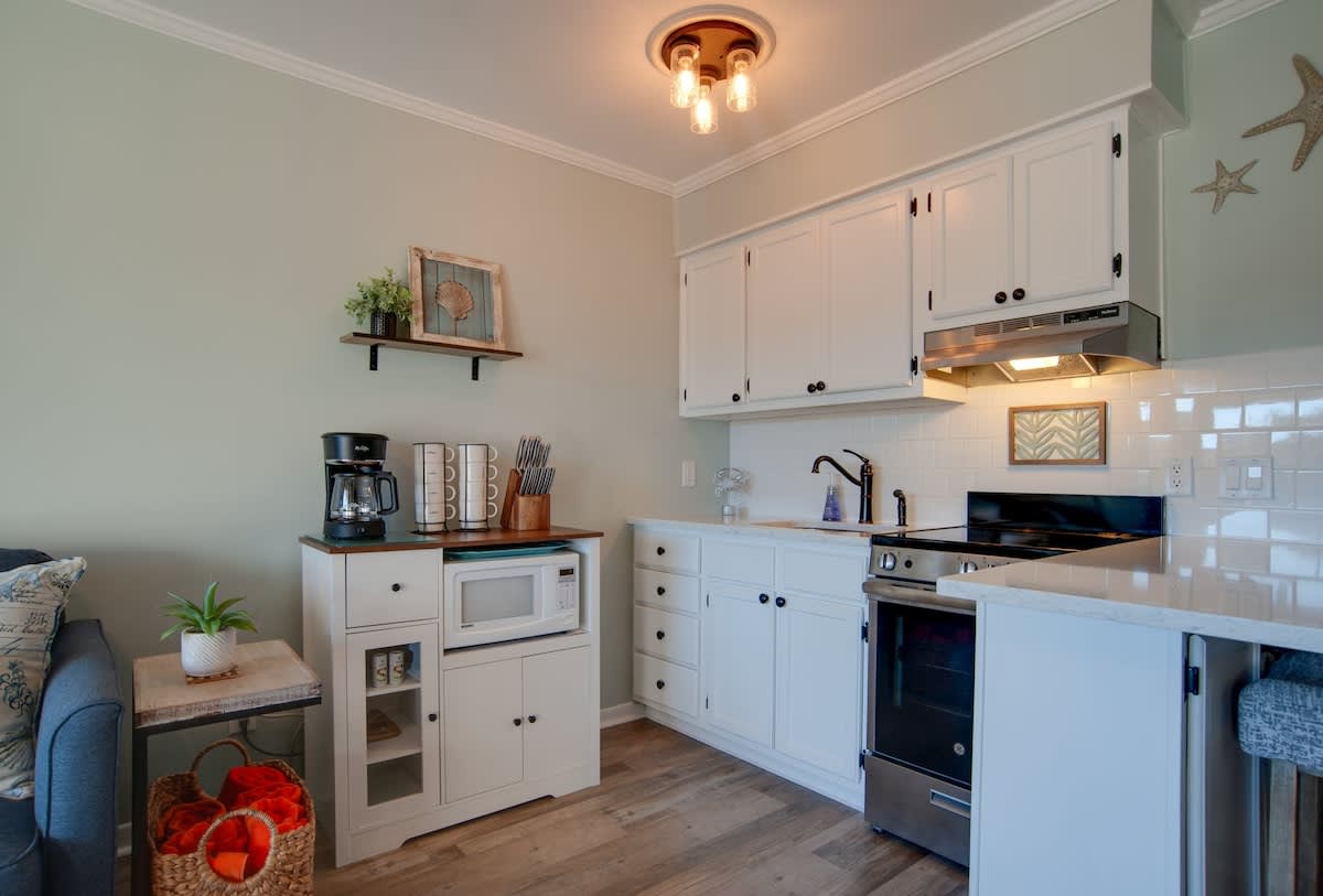 Your coastal-inspired kitchen awaits with white cabinetry, warm wood counters, and everything you need to create memorable meals during your stay.