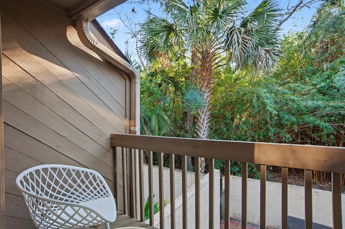 Step onto your private balcony where morning coffee tastes better surrounded by tropical palm trees and lush greenery.