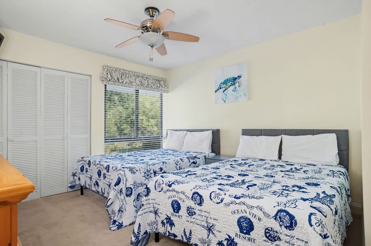 Drift off in your cheerful twin bedroom, where ocean-themed bedding and gentle ceiling fan breezes create the perfect coastal escape for restful nights.