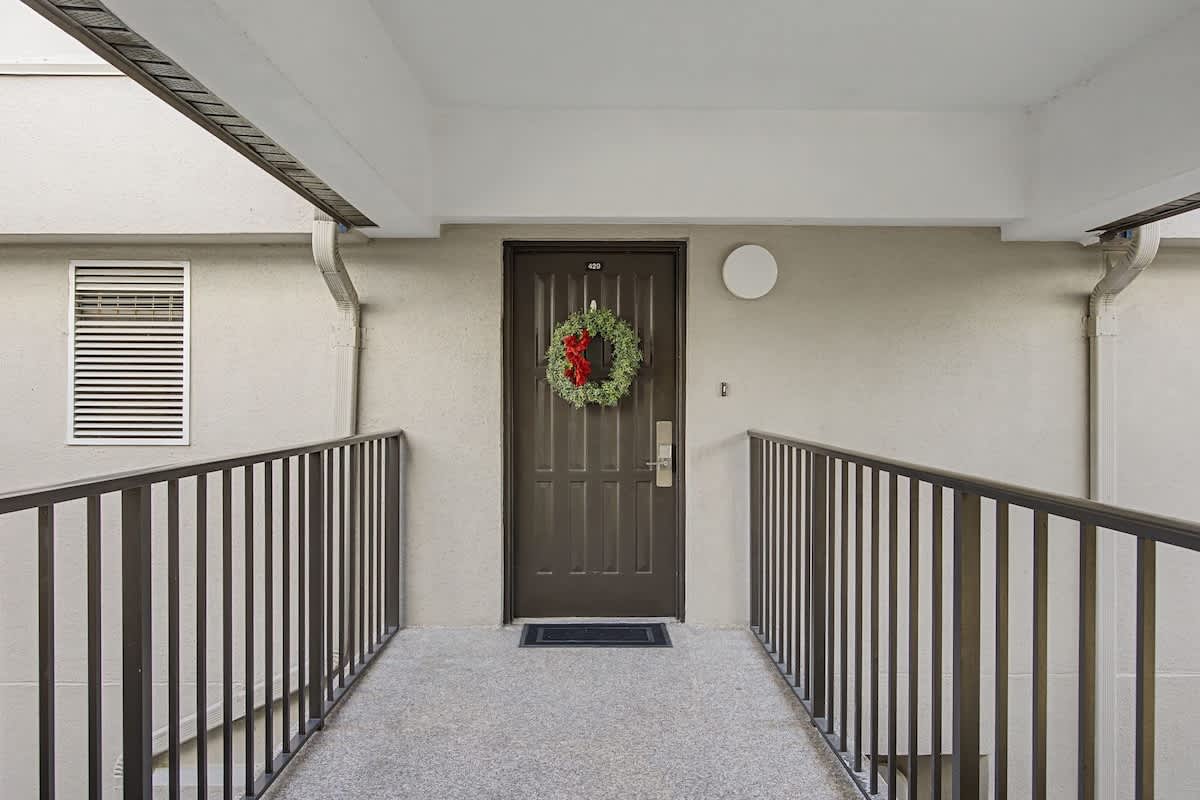 Welcoming entrance with festive wreath greets you at your private front door, complete with covered walkway for comfortable arrivals.