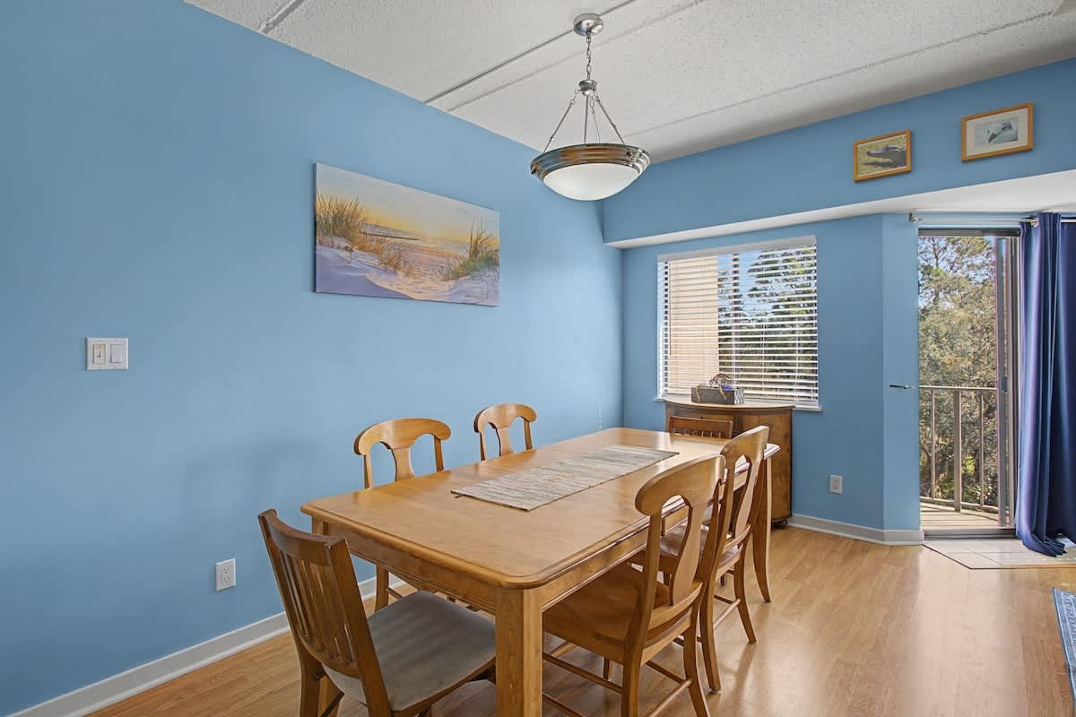 Gather around this warm dining table for memorable meals with your group, surrounded by soothing coastal artwork and natural light.