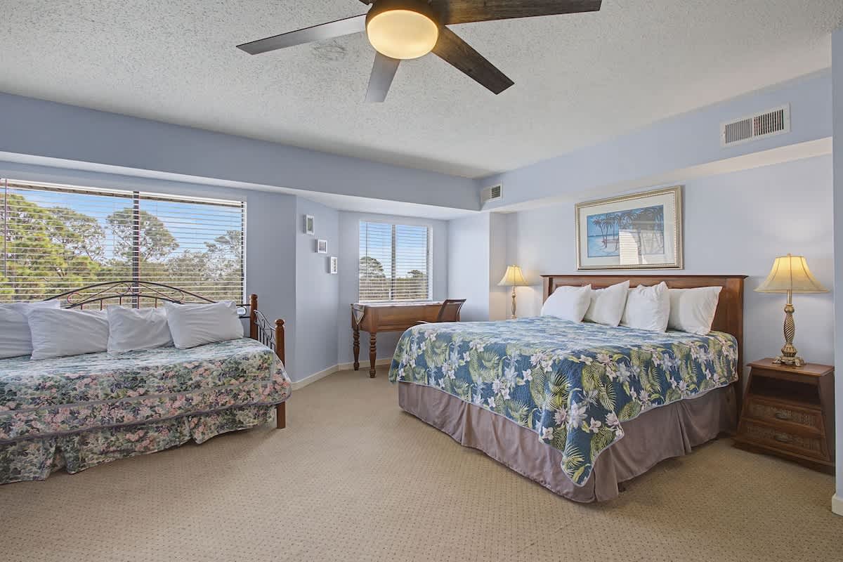 Wake up in this spacious bedroom where tropical bedding and gentle ceiling fan breezes create your perfect getaway retreat.