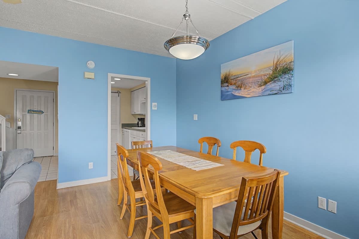 Gather around this welcoming dining table for memorable meals with loved ones in the bright, coastal-themed space.