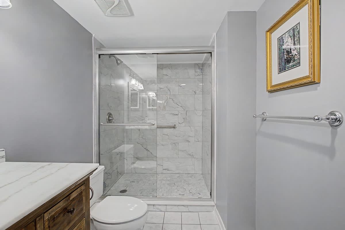 Step into your beautifully renovated bathroom featuring elegant marble-look tiles and a spacious walk-in shower where you'll feel pampered every morning.